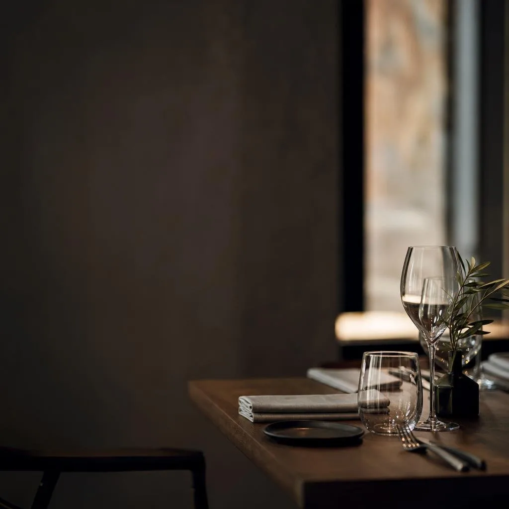 Elegantly set restaurant table with glassware and candlelight